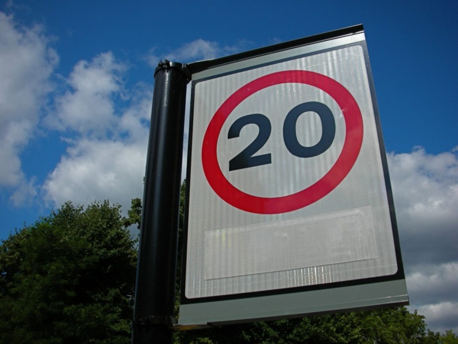 A street sign restricting car speeds to 20 miles per hour